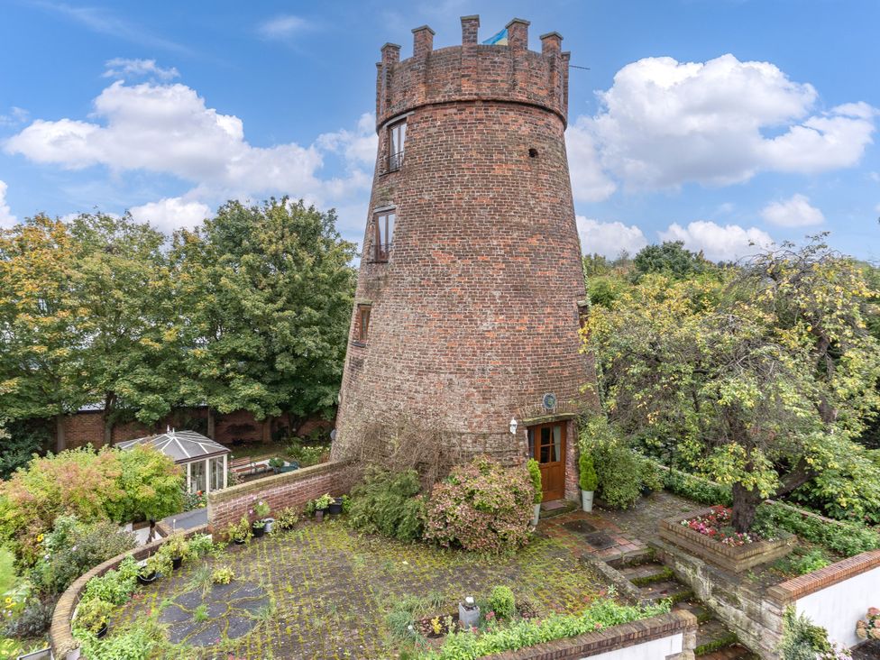 A windmill surrounded by plants and trees at Hadley Park Windmill