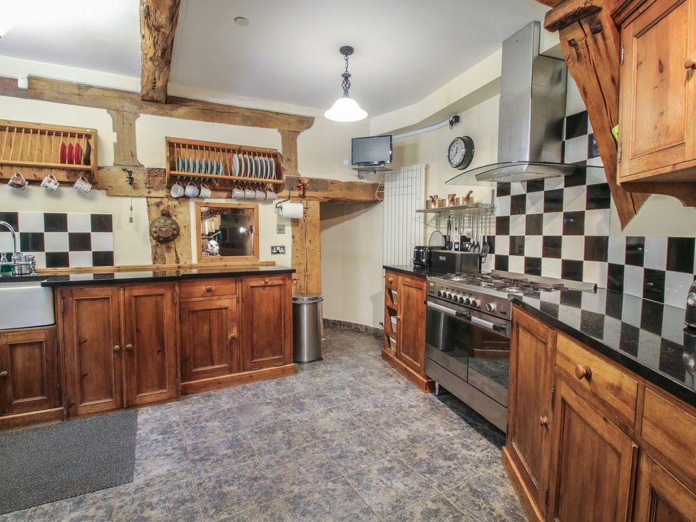 A kitchen with wooden cabinets and stainless steel appliances at Hadley Park Windmill near Telford
