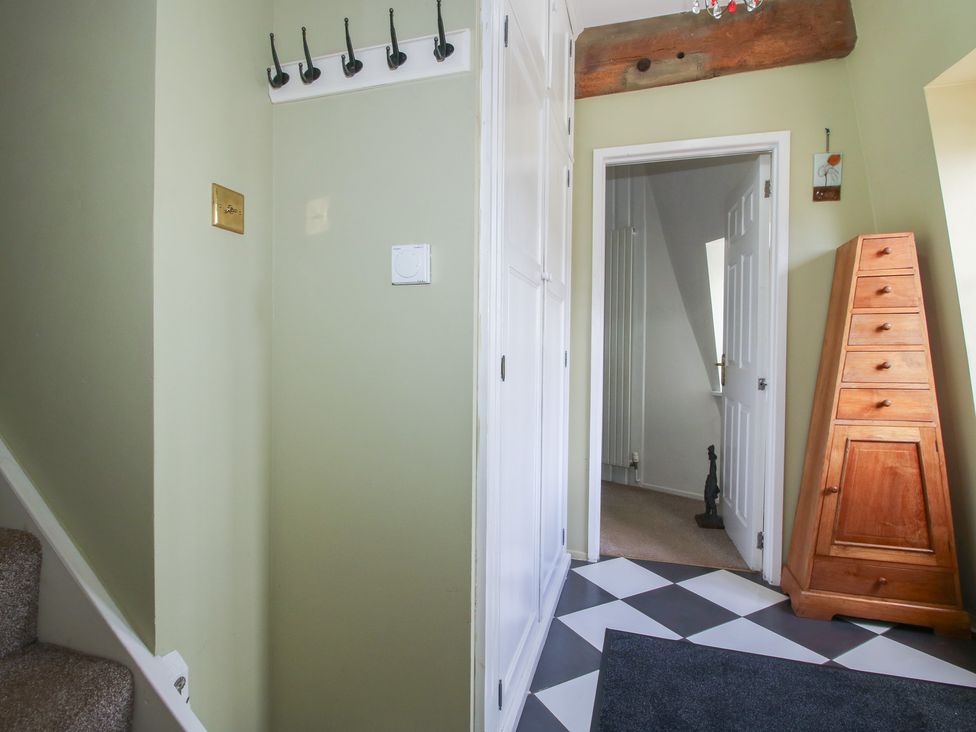 A hallway with stairs and a chest of drawers at Hadley Park Windmill near Telford