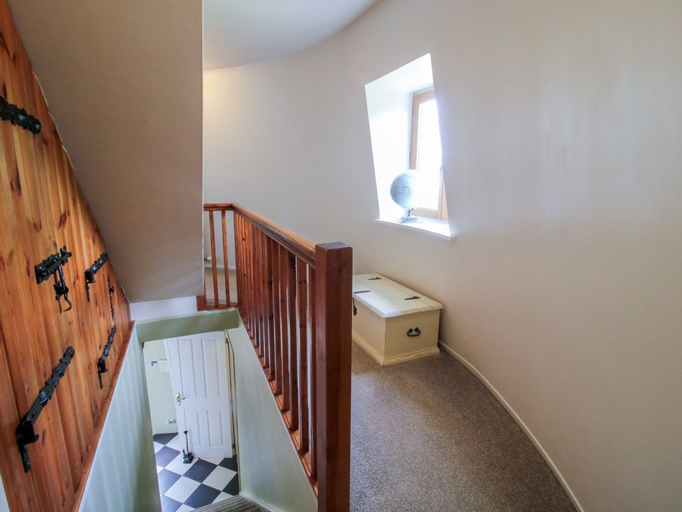 A hallway with a staircase and globe near a window at Hadley Park Windmill near Telford