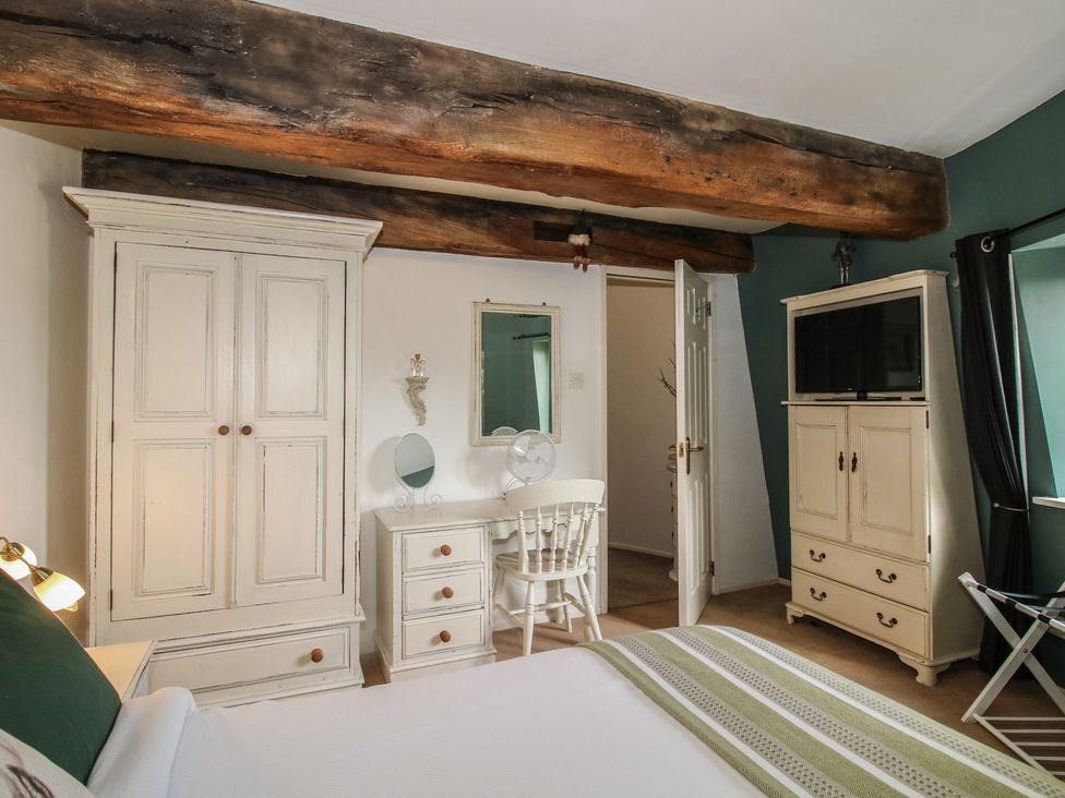A bedroom with a wardrobe, desk, and mirror at Hadley Park Windmill near Telford