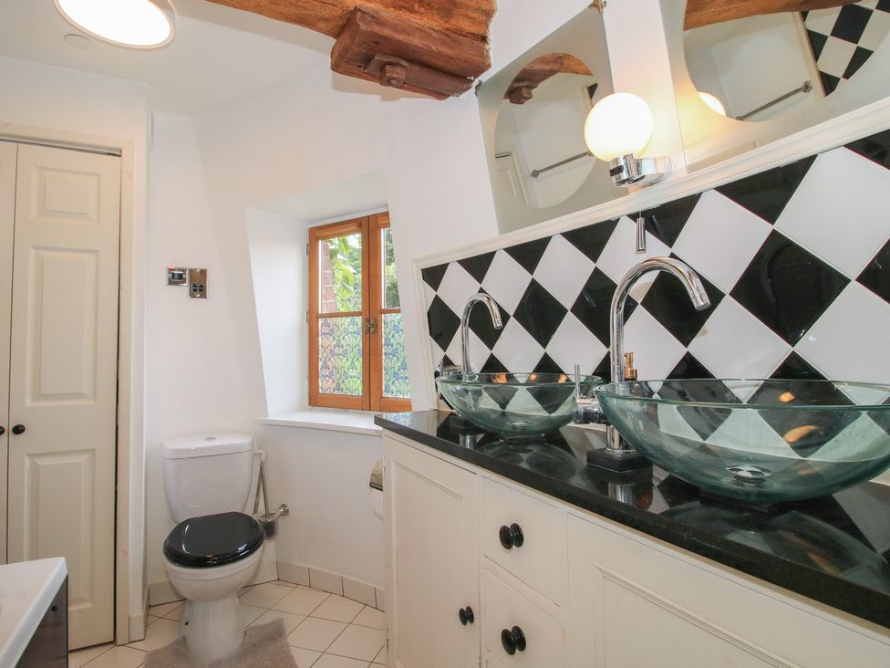 A bathroom with glass sinks and a toilet at Hadley Park Windmill near Telford
