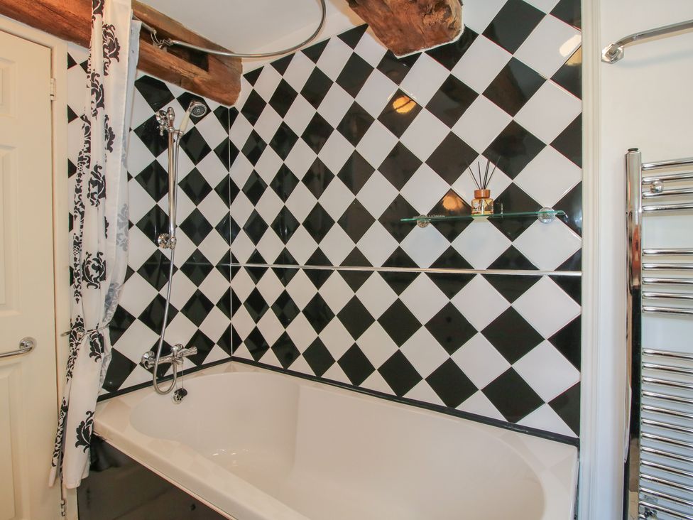 A bathroom with a bathtub and shower features at Hadley Park Windmill near Telford