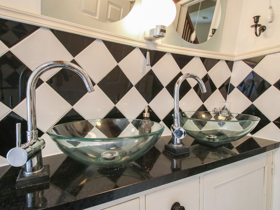 Two glass sinks with faucets in a bathroom at Hadley Park Windmill near Telford