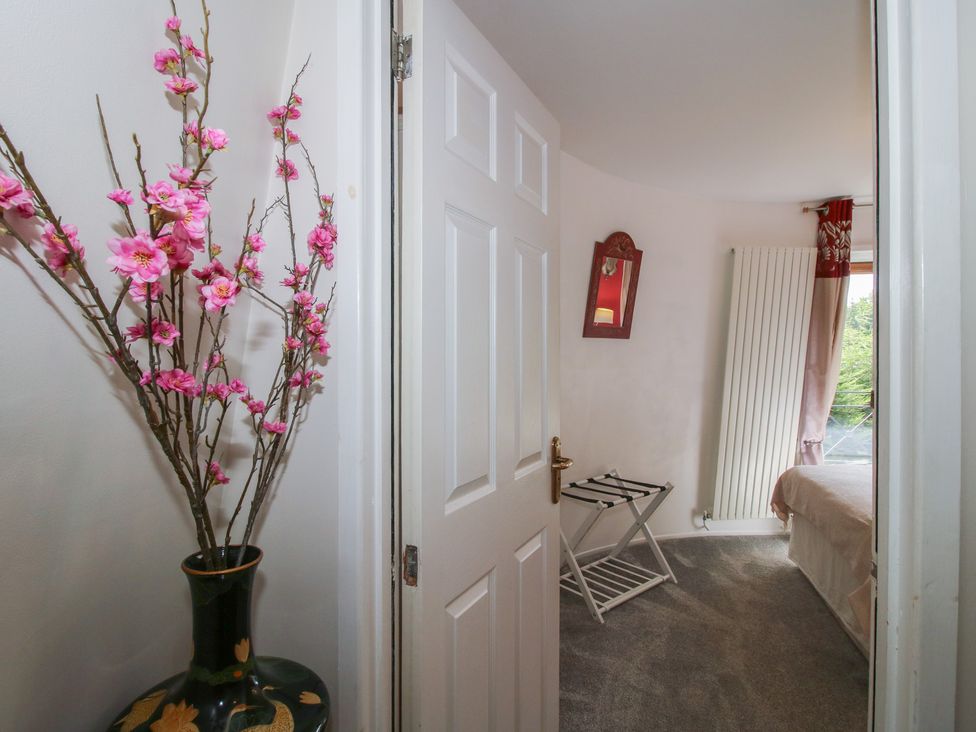 A bedroom with a bed and flowers in a vase at Hadley Park Windmill near Telford