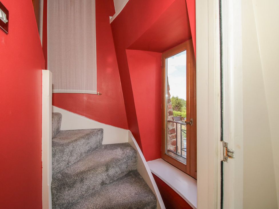 Stairs leading to a window with red walls at Hadley Park Windmill near Telford
