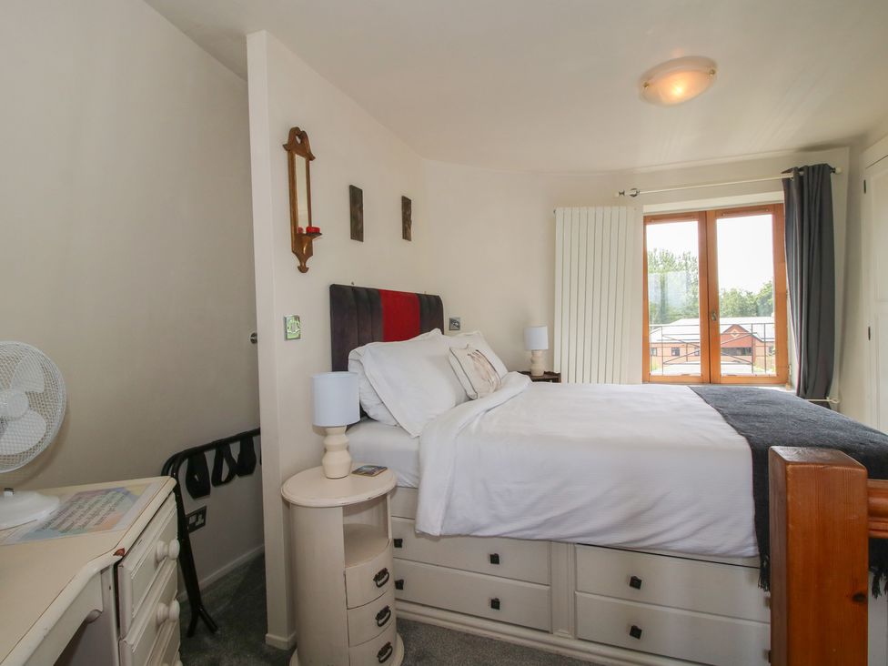 A bedroom with a bed and a dresser at Hadley Park Windmill near Telford