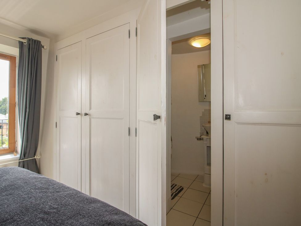 A bedroom with a wardrobe and a view into a bathroom at Hadley Park Windmill near Telford
