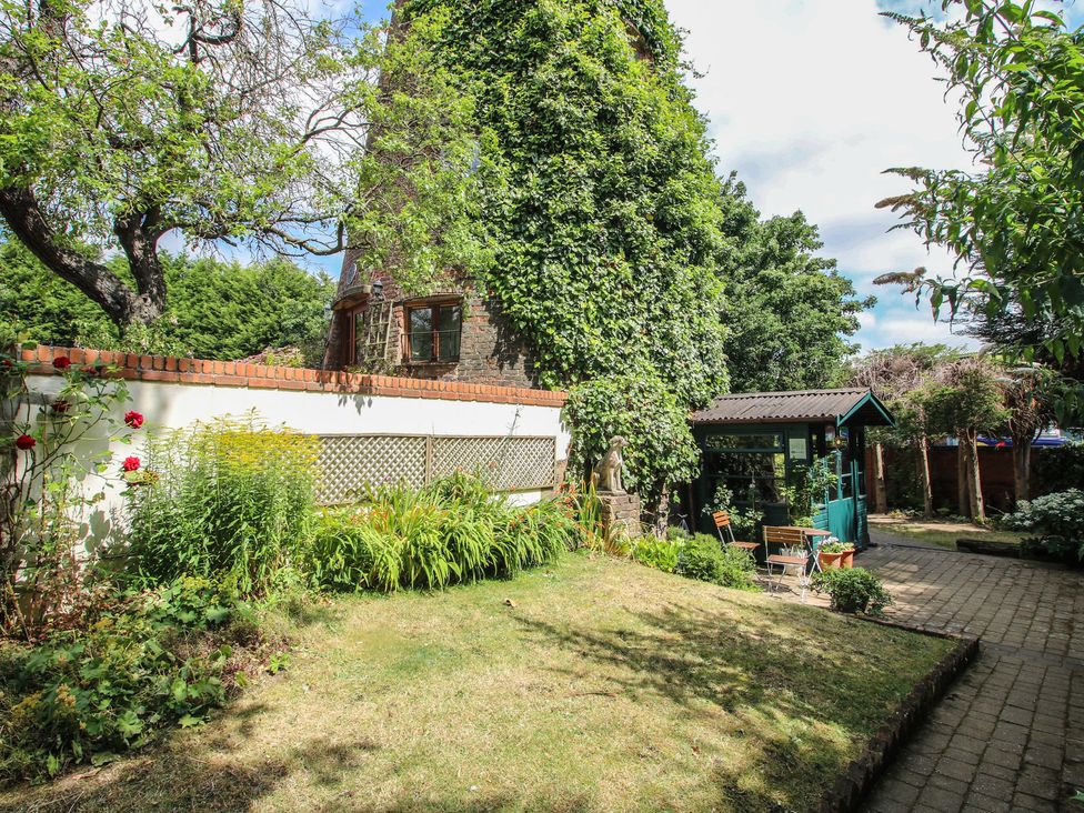 A garden with trees, flowers, a pathway and a garden shed at Hadley Park Windmill near Telford