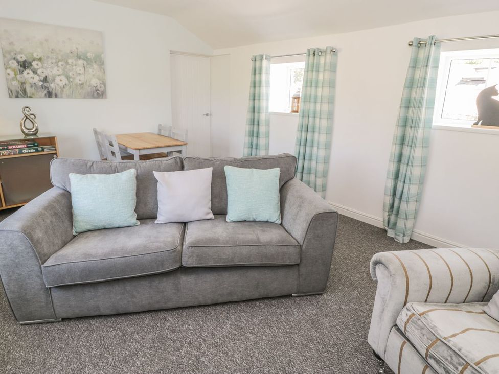 A living room with a sofa and table at Falconers Cottage