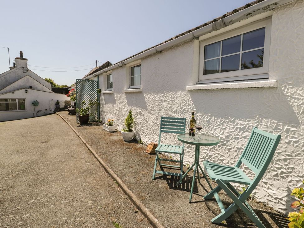 An outdoor area with chairs and a table at Falconers Cottage