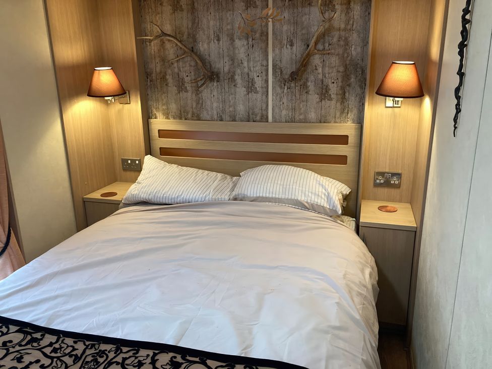 A bedroom with a bed and lamps at Beachside in Towyn