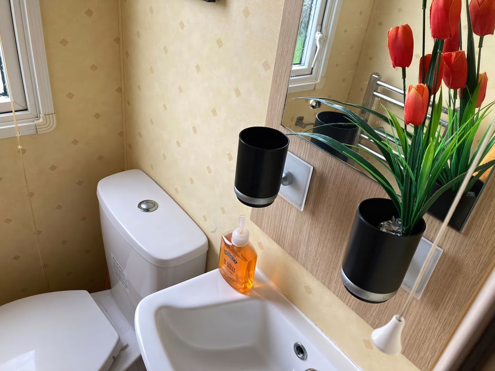 A bathroom with a toilet and sink at Beachside in Towyn