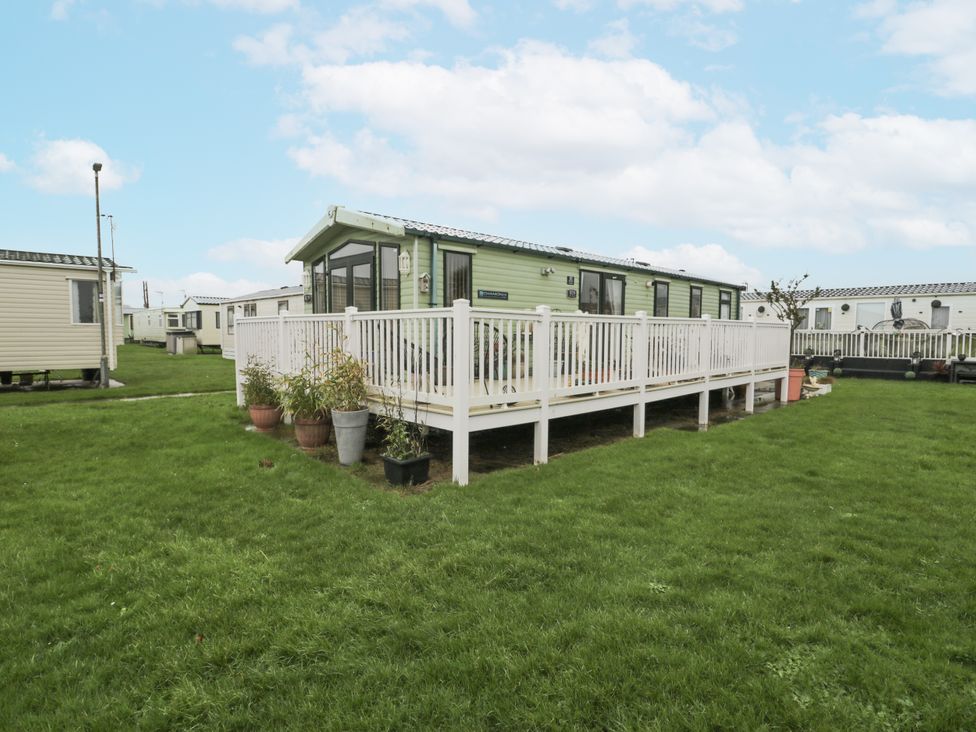 An outdoor area with a caravan and decking at Beachside in Towyn