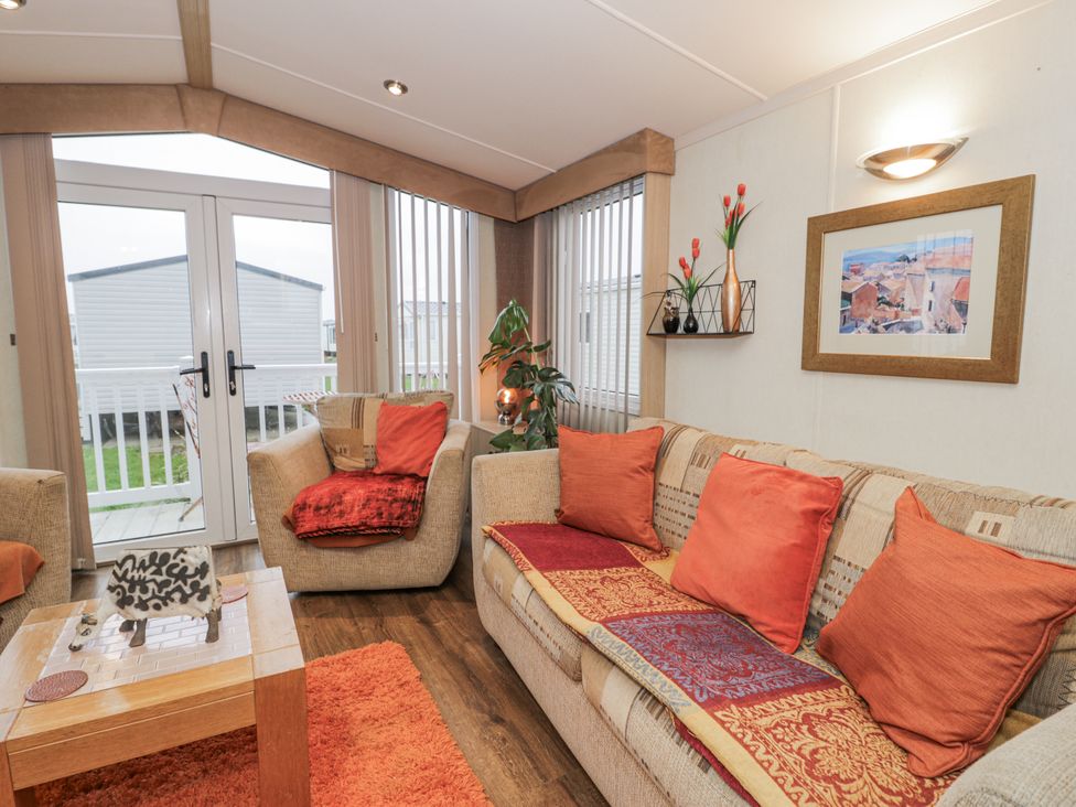 A living room with a sofa and coffee table at Beachside in Towyn