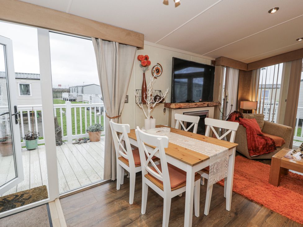 A dining room with a table and chairs at Beachside in Towyn