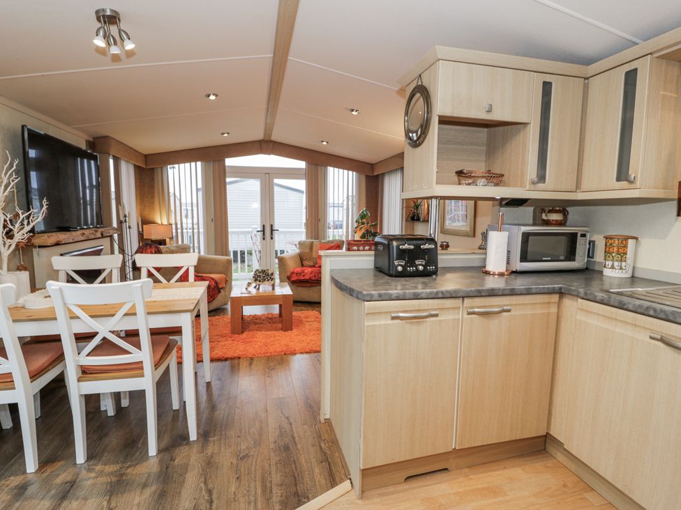 A kitchen with dining area and couch at Beachside in Towyn