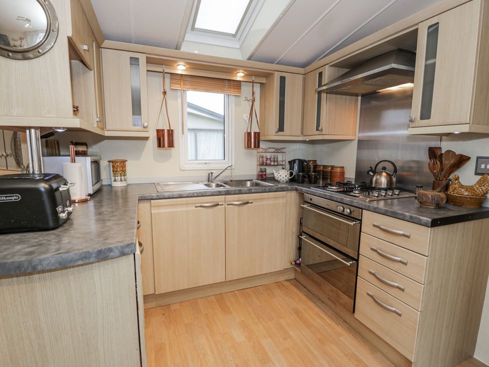 A kitchen with appliances and storage at Beachside in Towyn