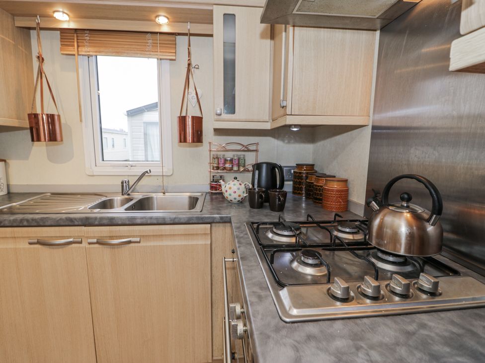 A kitchen featuring a sink and stove at Beachside in Towyn