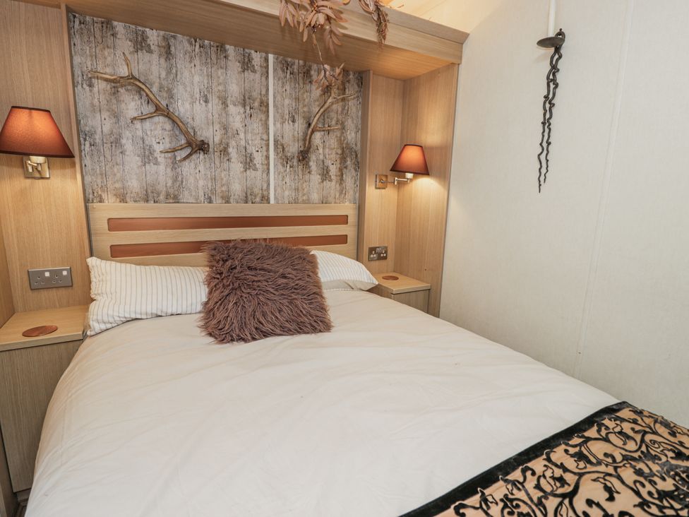 A bedroom with a bed and wall decor at Beachside in Towyn