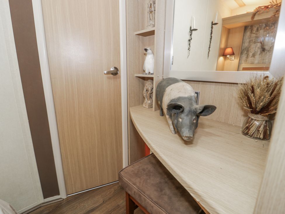 A shelf with decorative items and a door at Beachside in Towyn