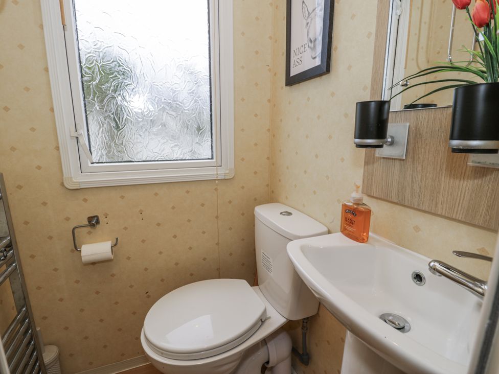 A bathroom with a toilet and sink at Beachside in Towyn