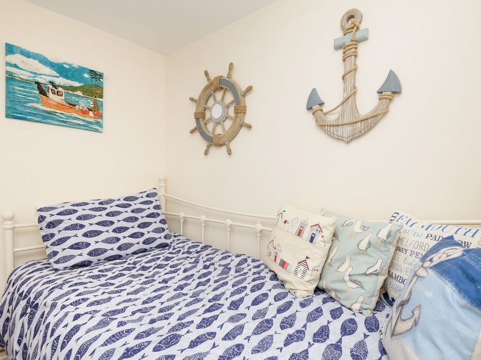 A bedroom with a bed and nautical decor at Dolls Cottage in Looe