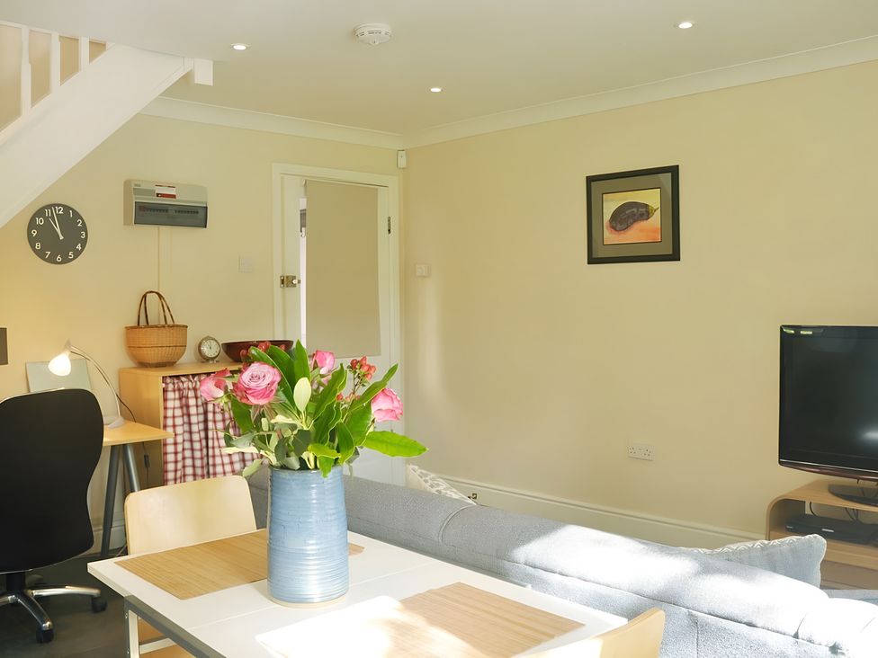 A living room with a sofa, table, and flowers at 45 School Road in Birmingham