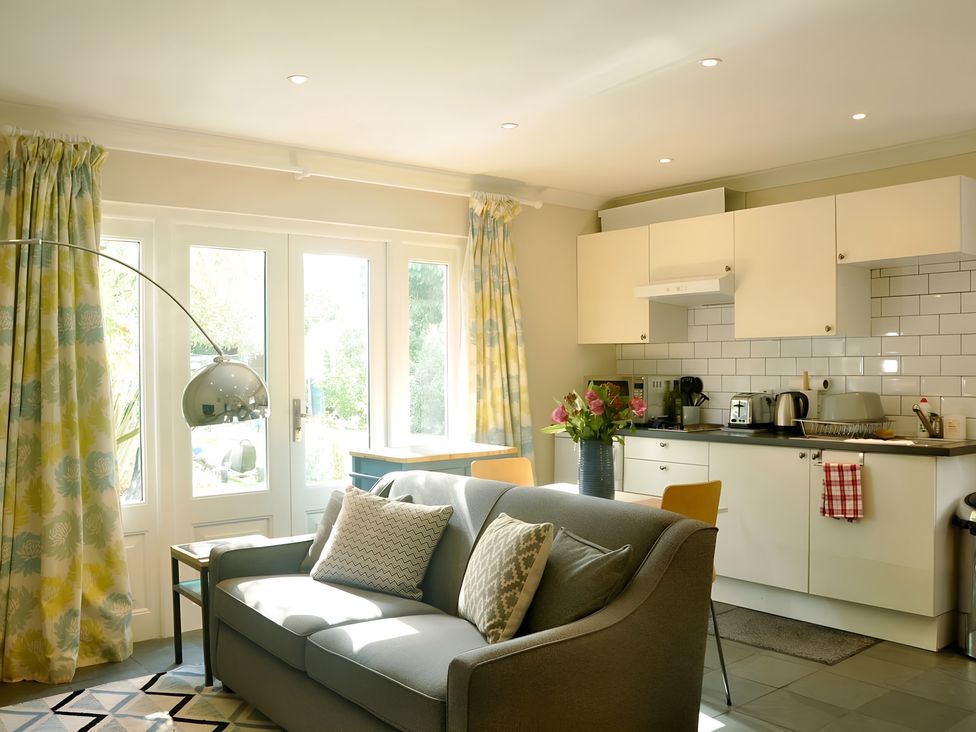 A living room with a sofa and kitchen area at 45 School Road Birmingham