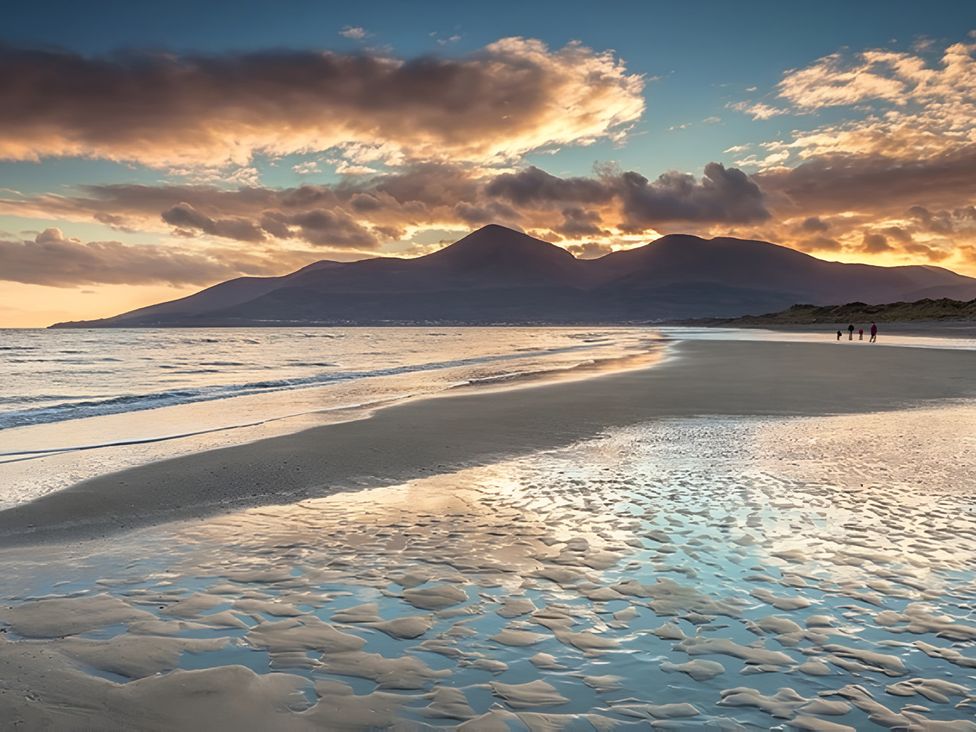 A beach with mountains and clouds at The Rocks in Newry