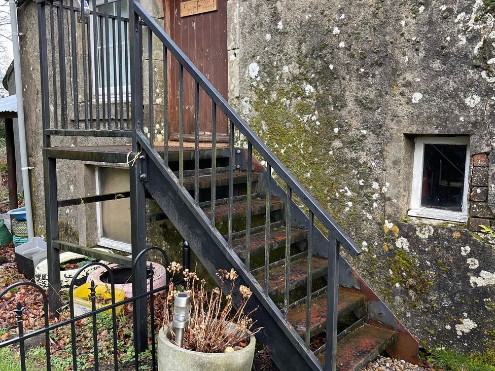 A staircase leading to a door next to a textured wall at Studio Apartment at High Dyke Farm Cockermouth