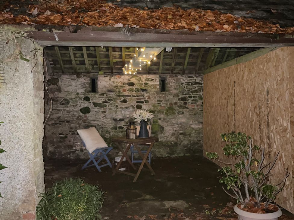 A seating area with a table and chair in an outdoor space at Studio Apartment at High Dyke Farm, Cockermouth