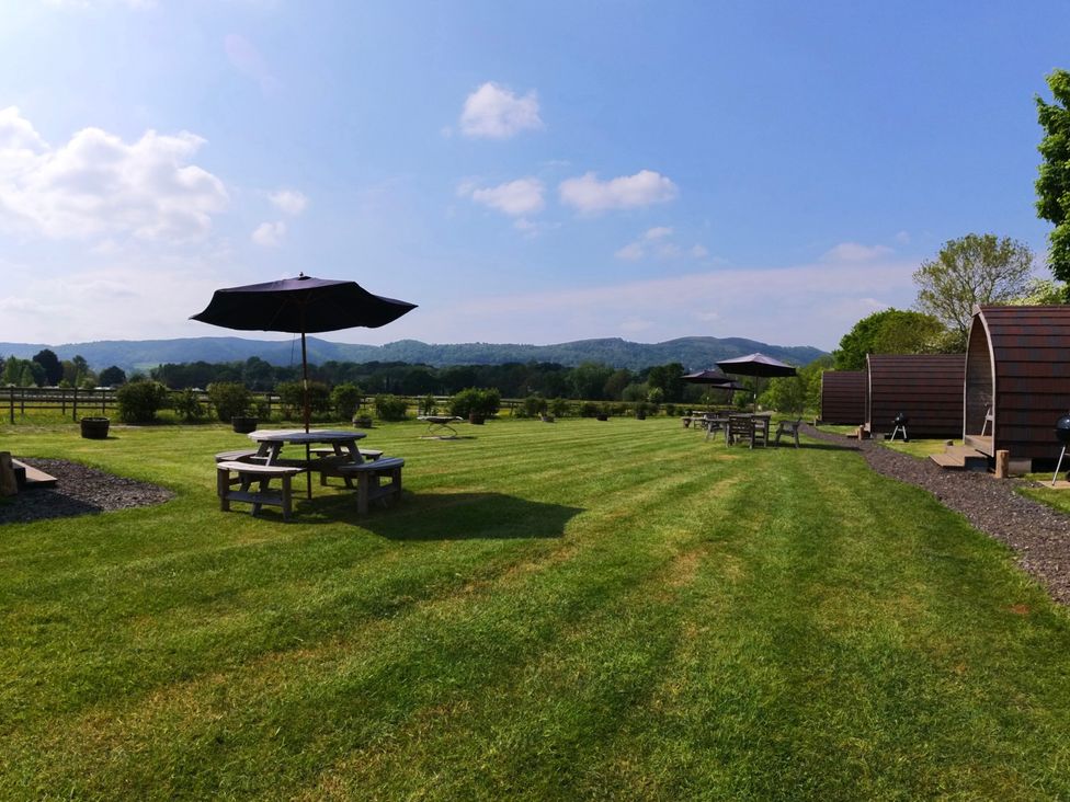 An outdoor area with tables and umbrellas at Rosebud Meadow Pod 2 Malvern