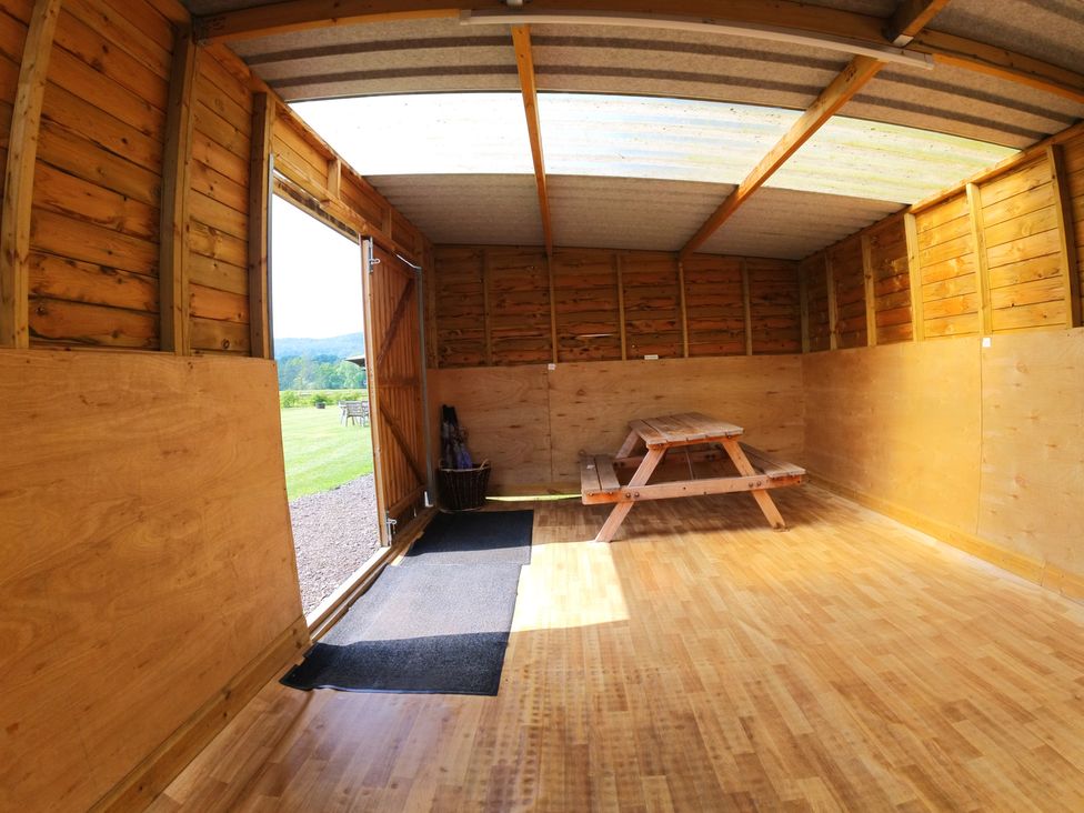 An indoor space with a picnic table and an open door at Rosebud Meadow Pod 3 Malvern
