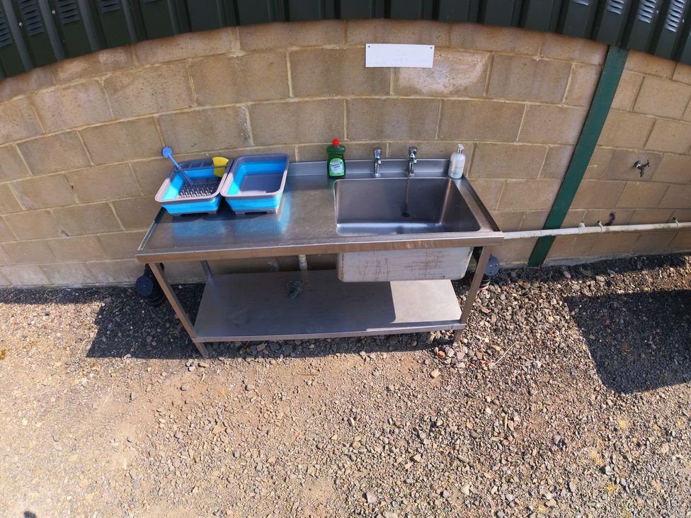 A sink with washing bowls and cleaning supplies at Rosebud Meadow Pod 3 Malvern