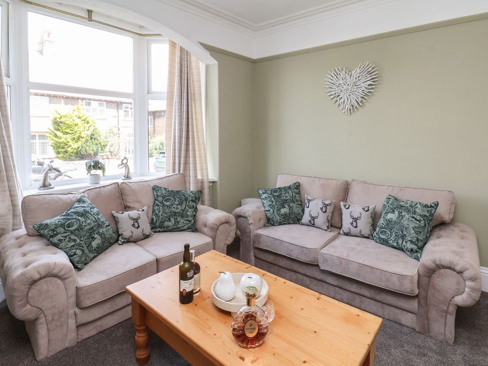 A living room with sofas and a coffee table at Crescent Bay House in Filey