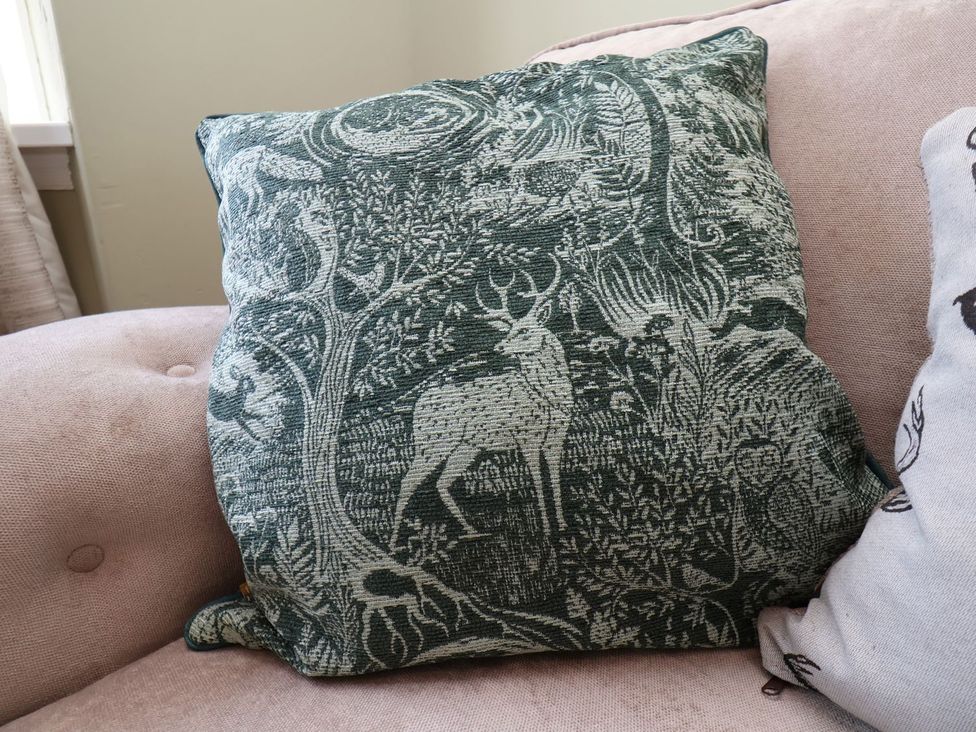 A cushion with a forest design on a sofa at Crescent Bay House in Filey