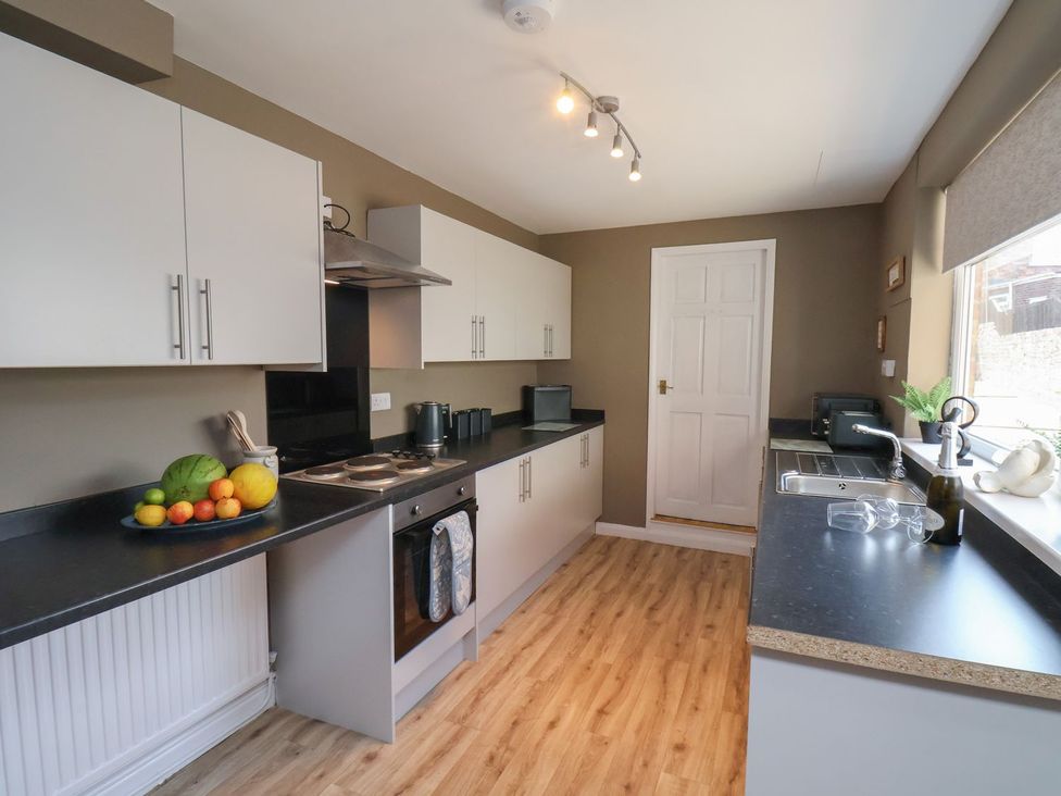 A kitchen with cabinets and a sink at Crescent Bay House in Filey