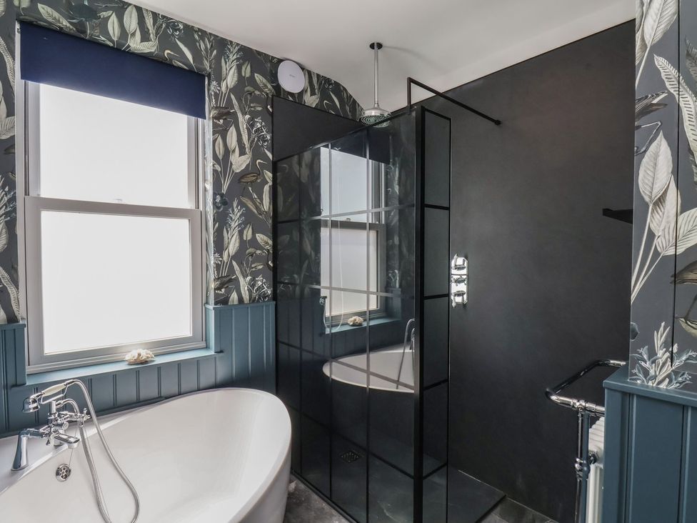A bathroom with a bathtub and shower at Crescent Bay House in Filey