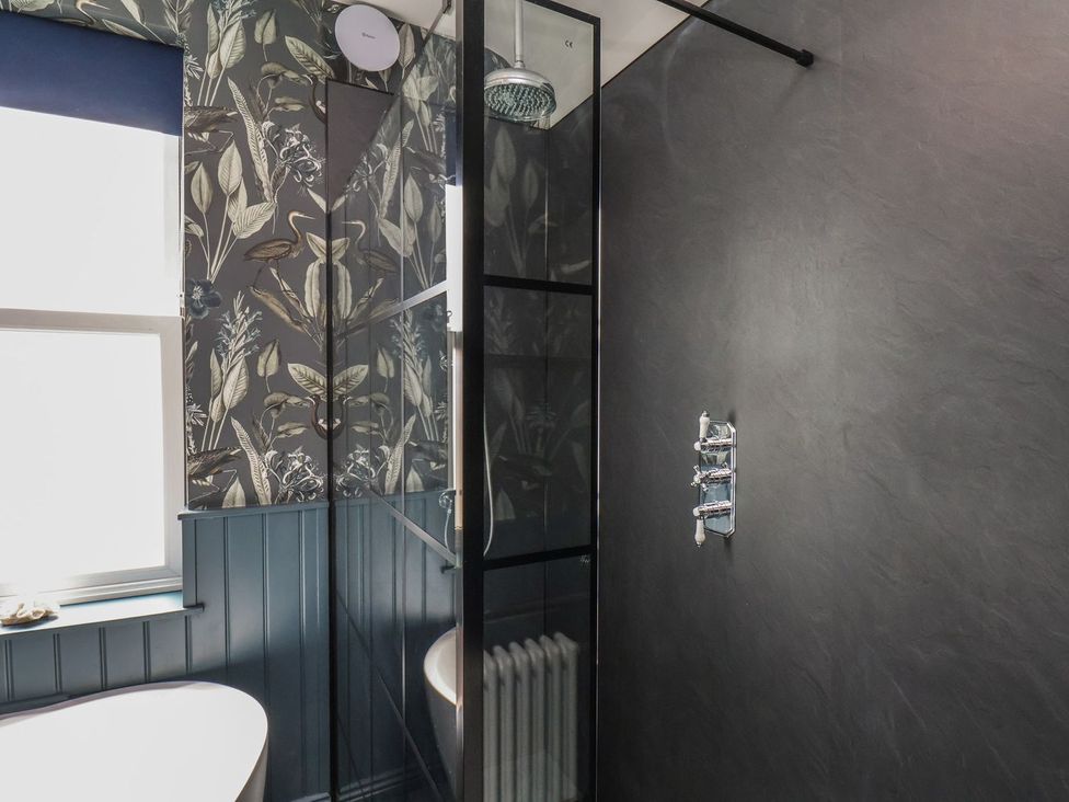 A bathroom with a shower and toilet at Crescent Bay House in Filey
