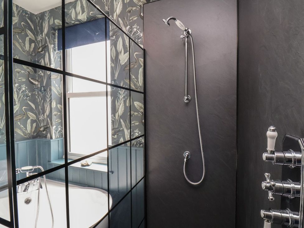 A bathroom with a shower and bathtub at Crescent Bay House in Filey
