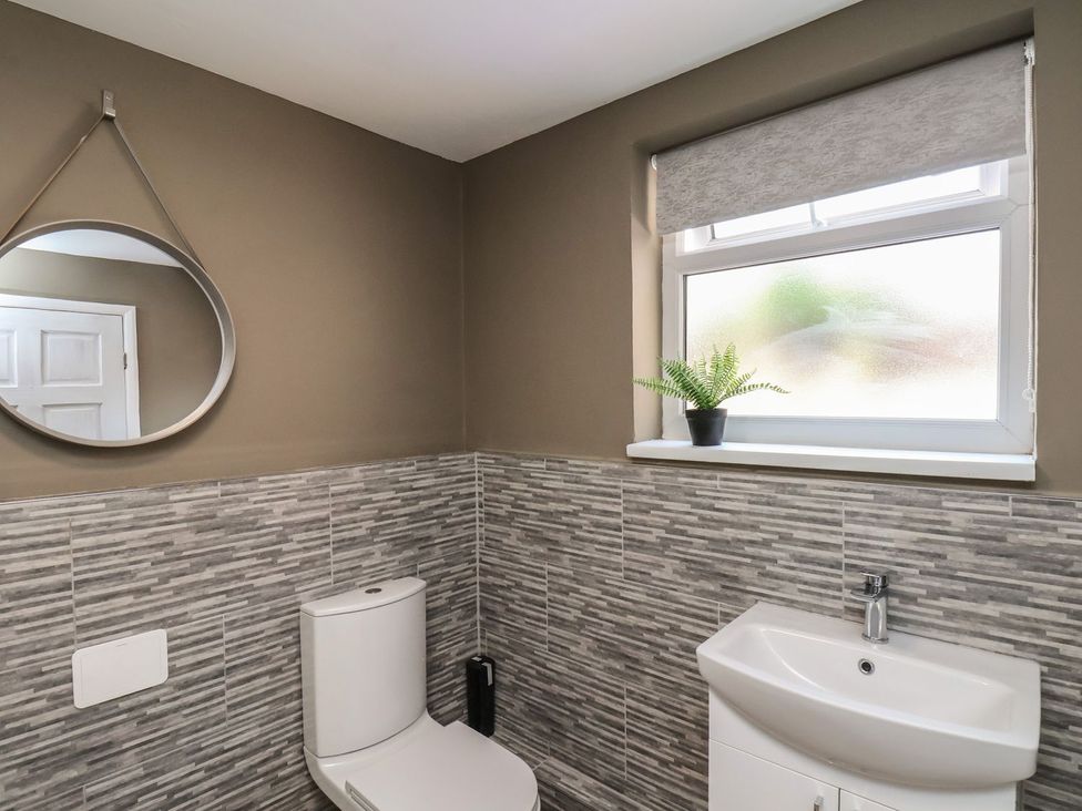 A bathroom with a toilet and sink at Crescent Bay House, Filey