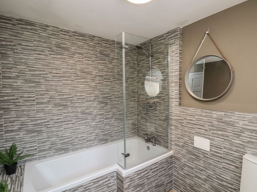 A bathroom with bathtub and shower at Crescent Bay House in Filey