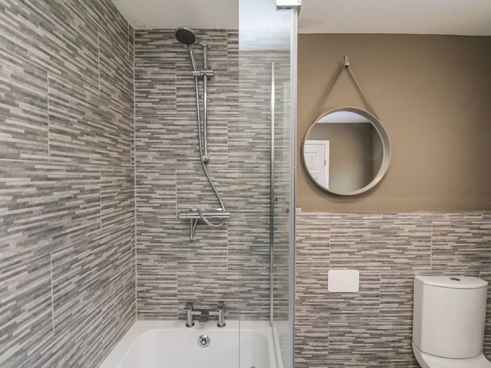 A bathroom with a shower and bathtub at Crescent Bay House in Filey