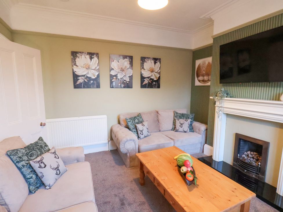 A living room with a sofa and a coffee table at Crescent Bay House in Filey