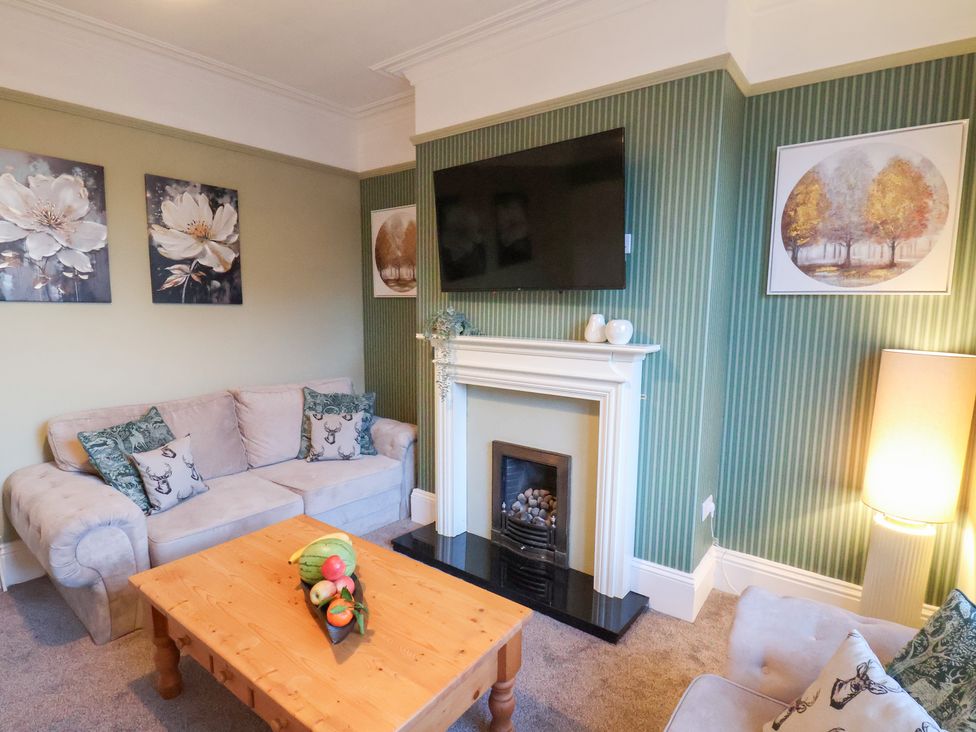 A living room with a sofa and coffee table at Crescent Bay House in Filey