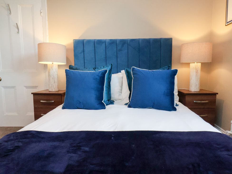 A bedroom with a bed and lamps at Crescent Bay House in Filey