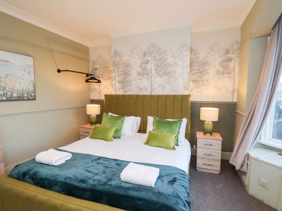 A bedroom with a bed and bedside tables at Crescent Bay House in Filey