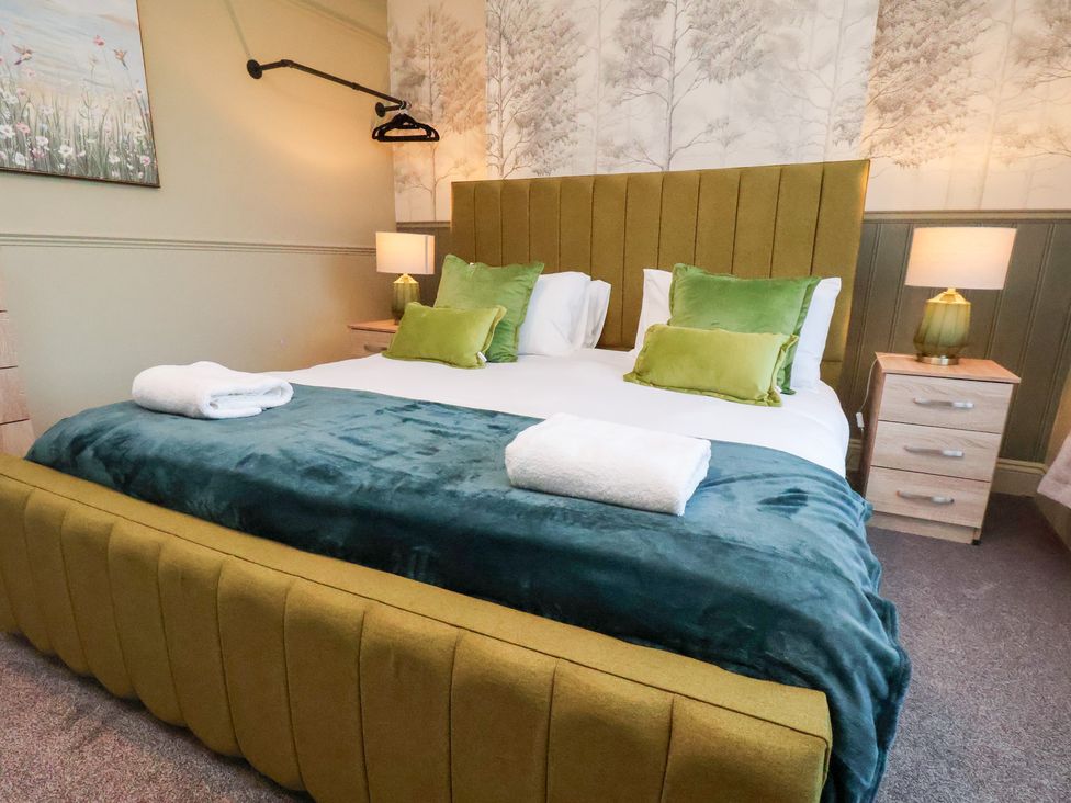 A bedroom with a bed and bedside tables at Crescent Bay House in Filey