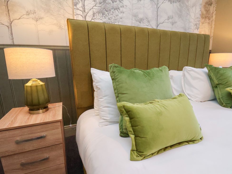 A bedroom with a bed and pillows at Crescent Bay House in Filey